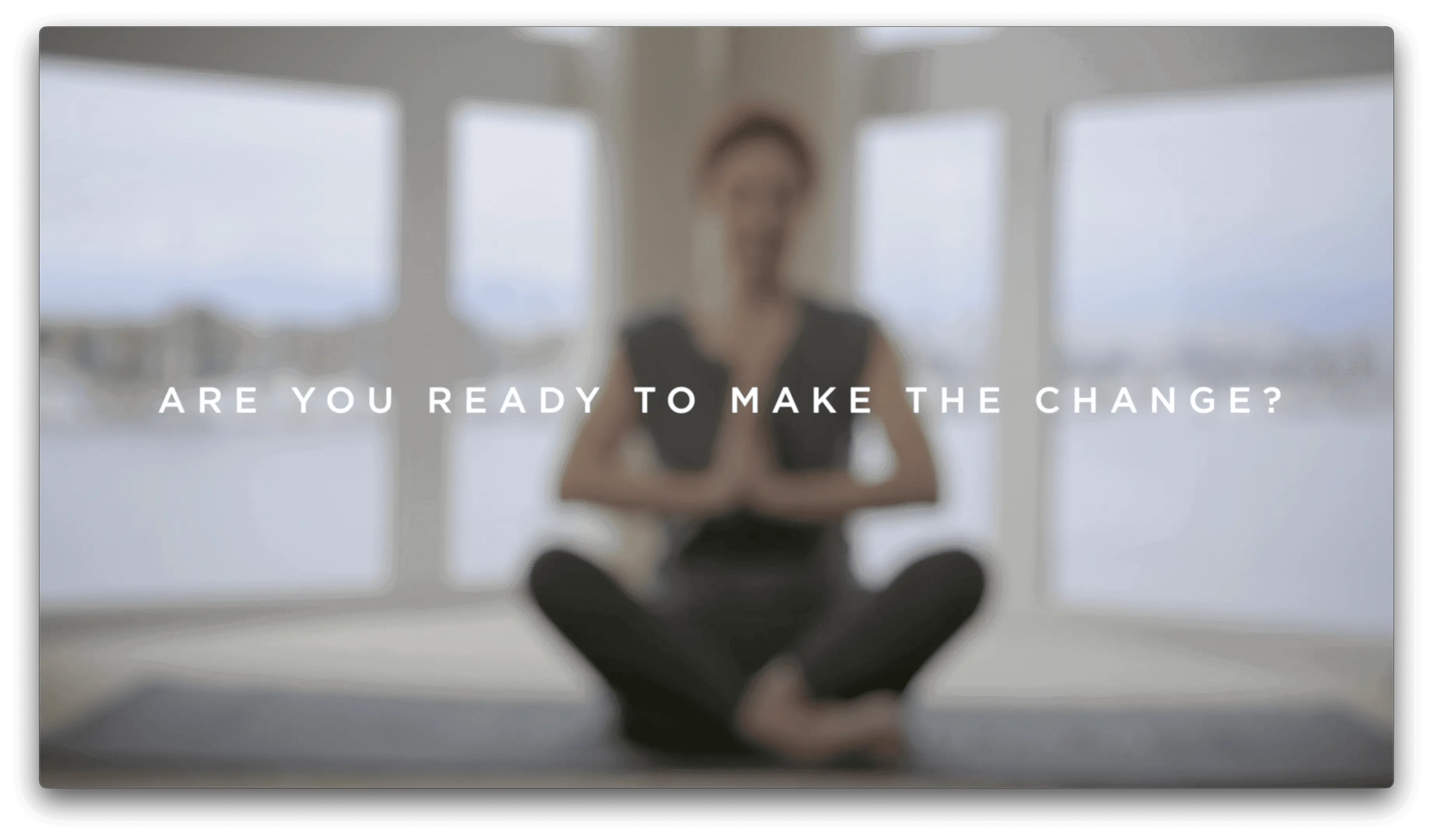 A woman sitting in the middle of her yoga class.
